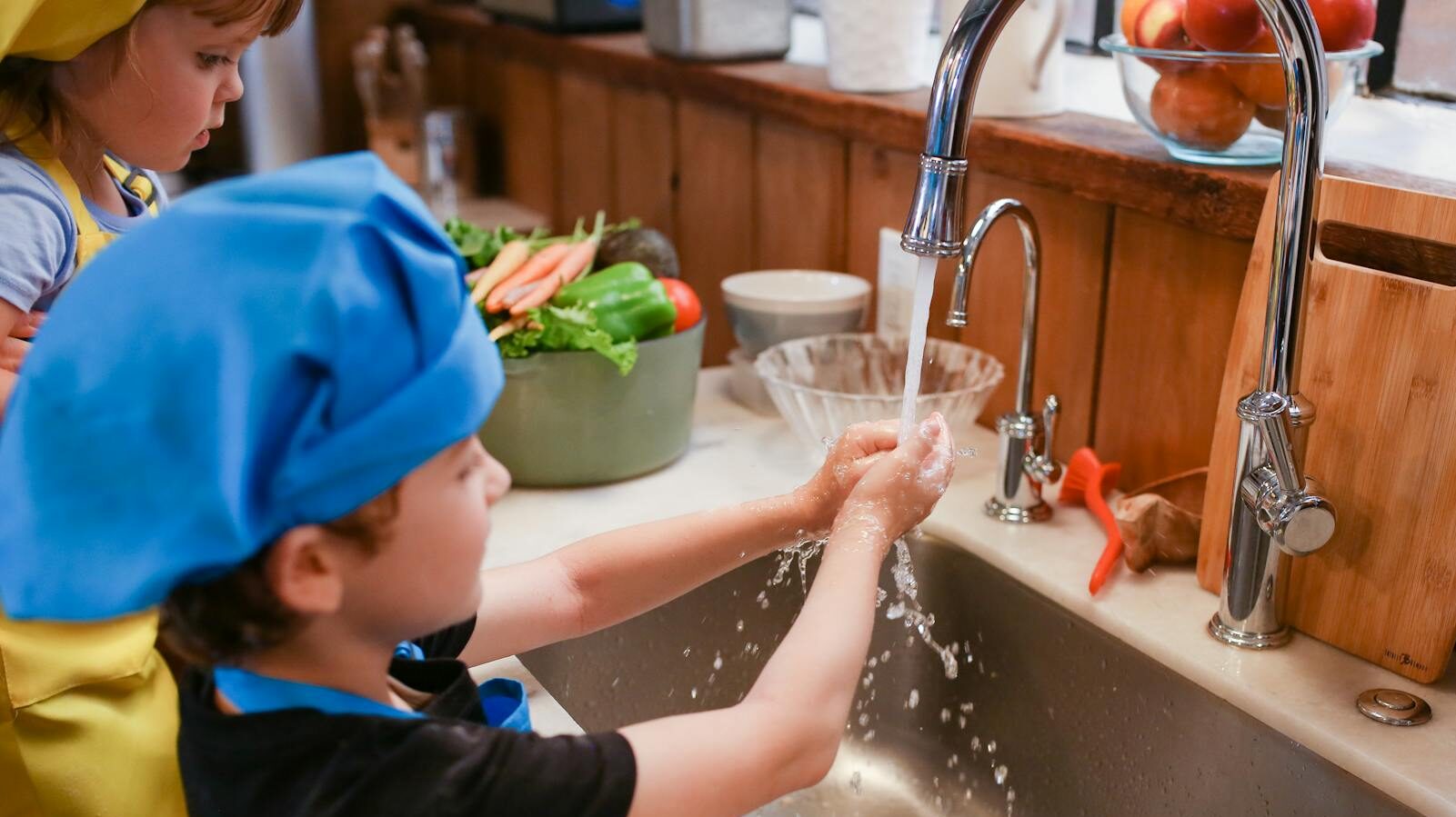 boy in blue shirt and blue cap in bathtub